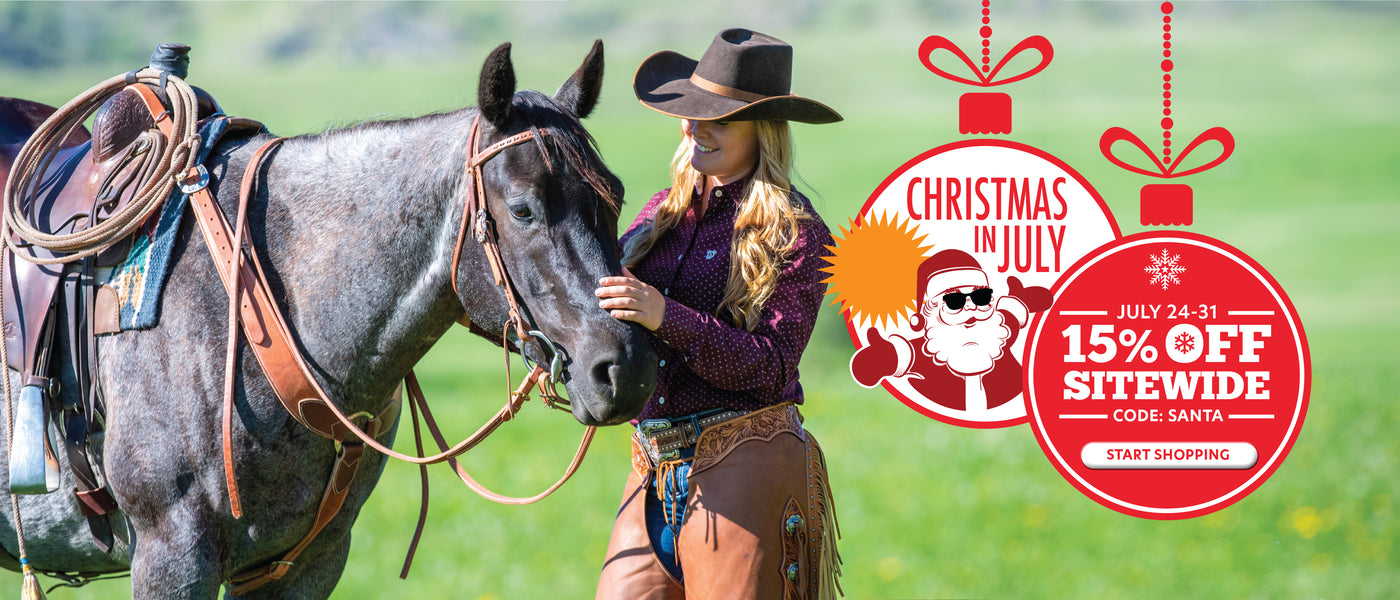 Cowgirl standing beside a saddled gray horse with a Christmas in July 15% off sitewide promotion.